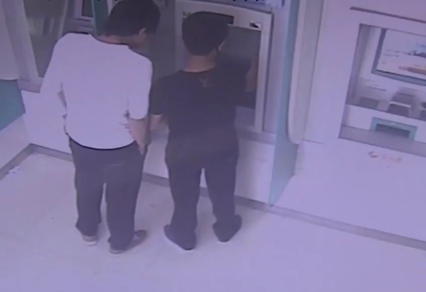 Hai thanh niên rút tiền từ thẻ của Cường. Ảnh: CCTV.