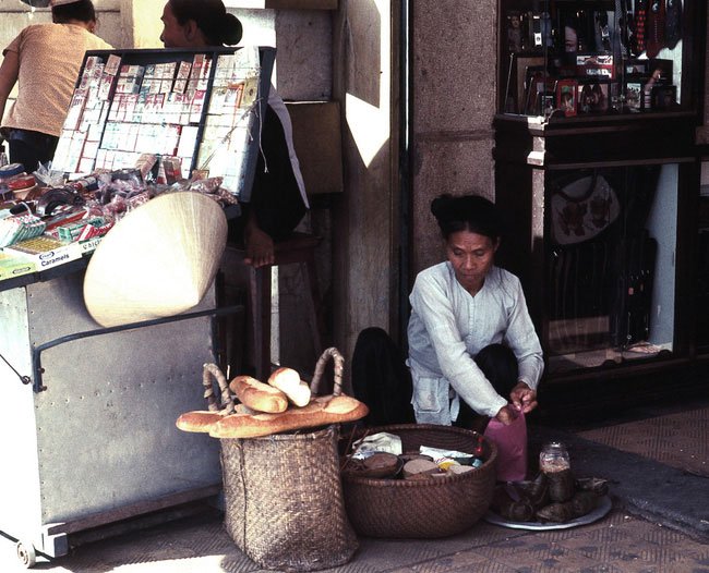 Cụ bà bán bánh mì bên vỉa hè đại lộ Lê Lợi, 1968.