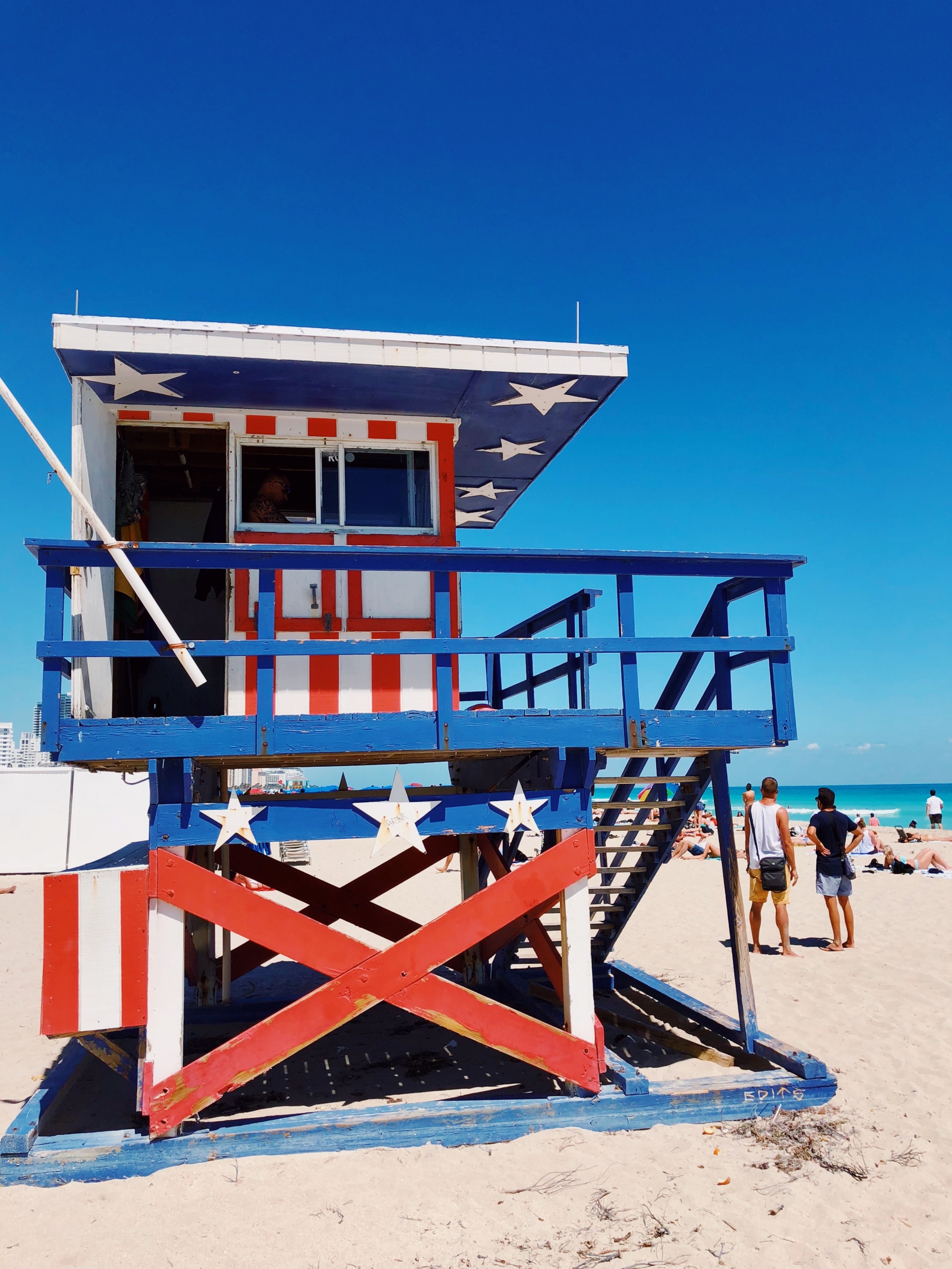 white, blue, and red American flag printed wooden lifeguard house on beach