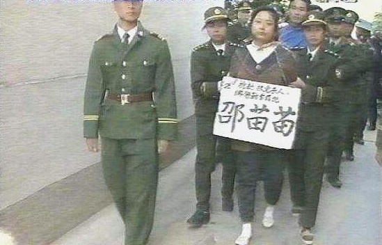 Thiệu Miêu Miêu và Kiều Lập Phu (áo xanh biển) bị cảnh sát áp giải ra pháp trường. Ảnh: TVBJade