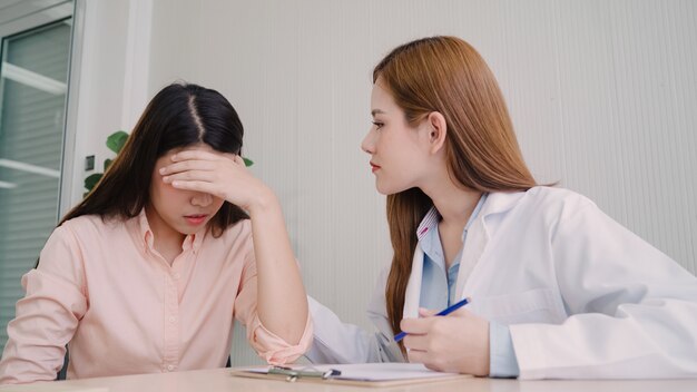 Free photo doctor talking to unhappy teenage patient in exam room.